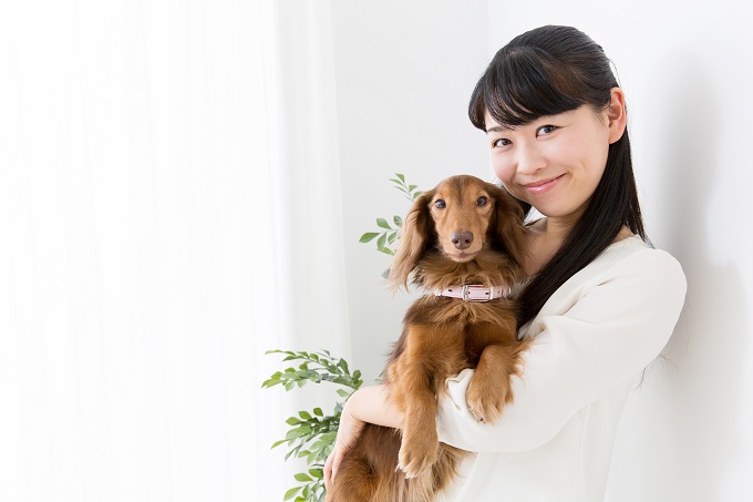 犬を抱っこする女性