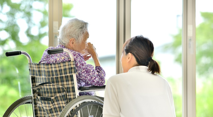 車いすの女性と話す介護士